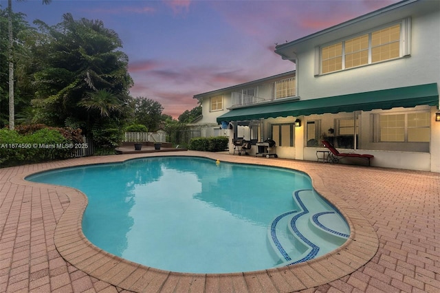 pool at dusk with a patio