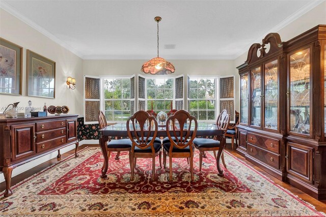 dining area featuring crown molding and dark wood-type flooring