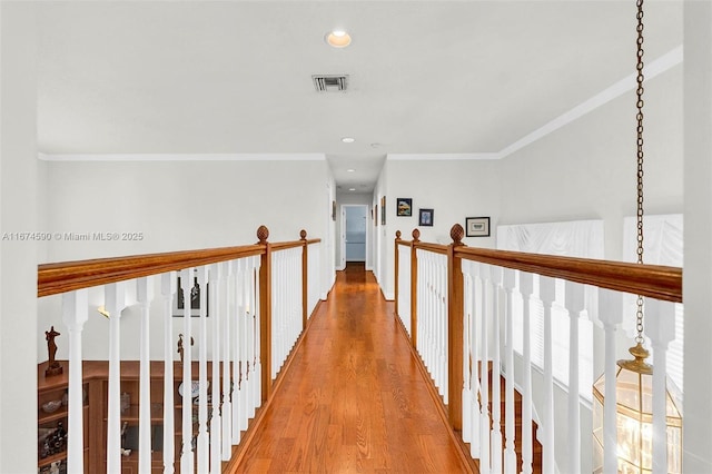 corridor featuring crown molding and light hardwood / wood-style flooring