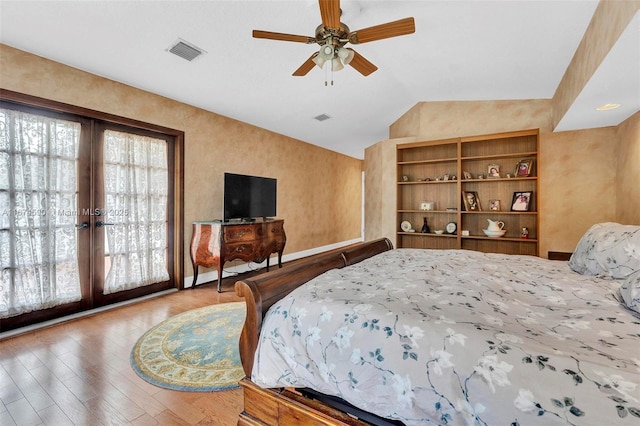 bedroom featuring ceiling fan, french doors, hardwood / wood-style floors, and vaulted ceiling