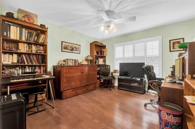 home office with ceiling fan and light hardwood / wood-style floors