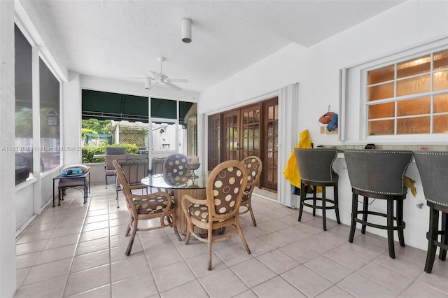 tiled dining room featuring ceiling fan and a textured ceiling