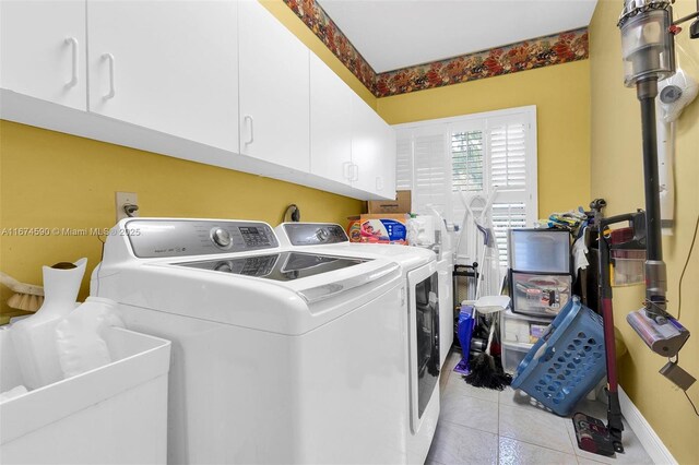 laundry area with washer and clothes dryer, light tile patterned flooring, cabinets, and sink