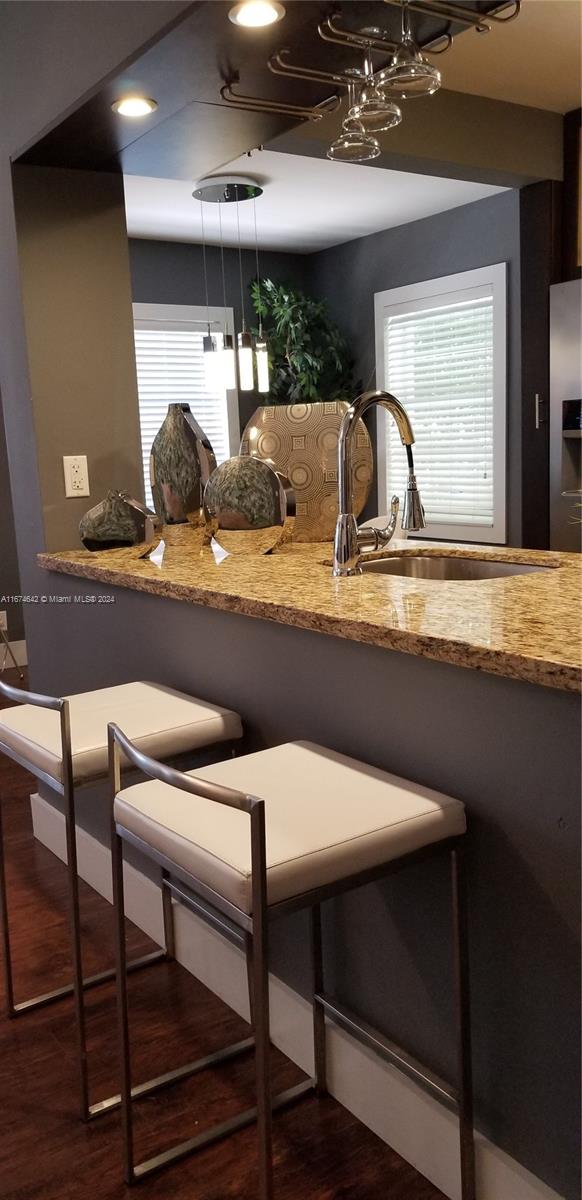 kitchen with stacked washer and dryer and light stone counters