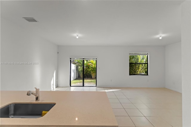 kitchen featuring sink, light tile patterned floors, and a healthy amount of sunlight