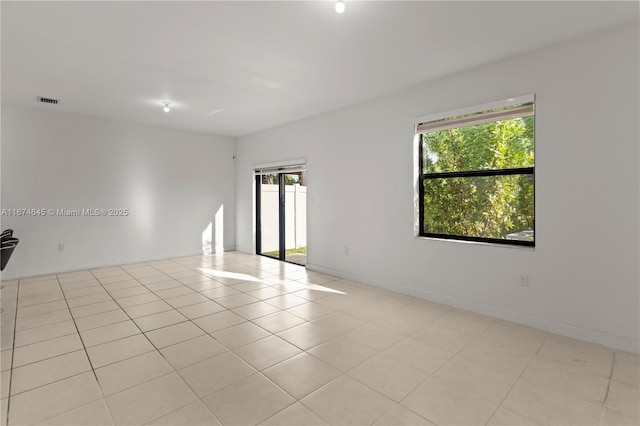 unfurnished room featuring light tile patterned floors and plenty of natural light