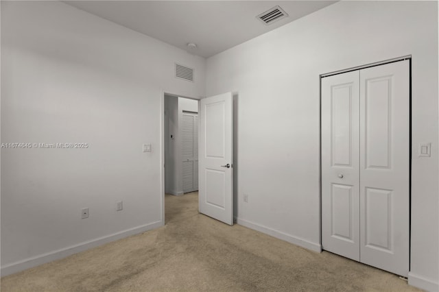 unfurnished bedroom with light carpet and a closet