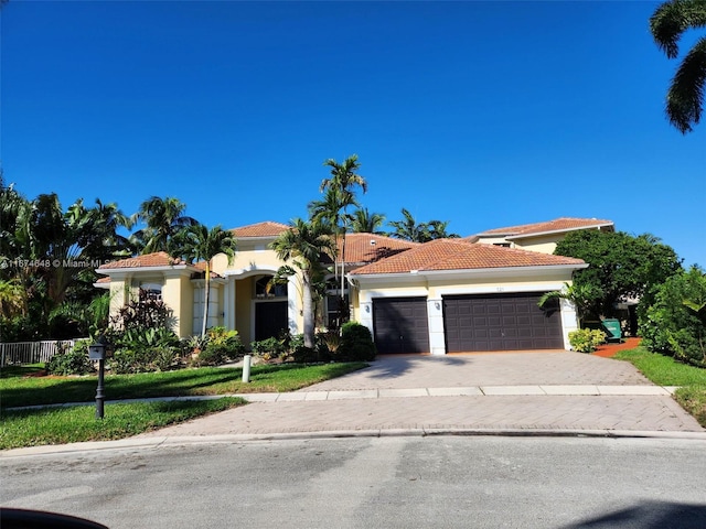321 Windmill Palm Ave, Plantation, FL 33324 - mediterranean / spanish-style house featuring driveway, stucco siding, a garage, a tiled roof, and a front lawn