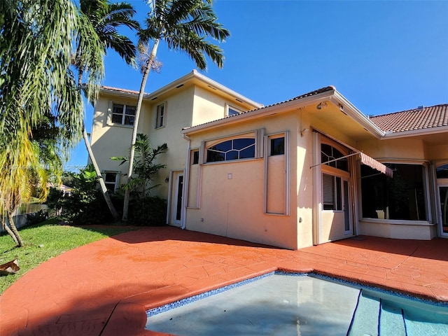 321 Windmill Palm Ave, Plantation, FL 33324 - back of property with stucco siding, a patio, and an outdoor pool