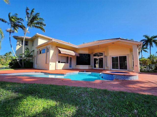 back of property with a lawn and a patio area