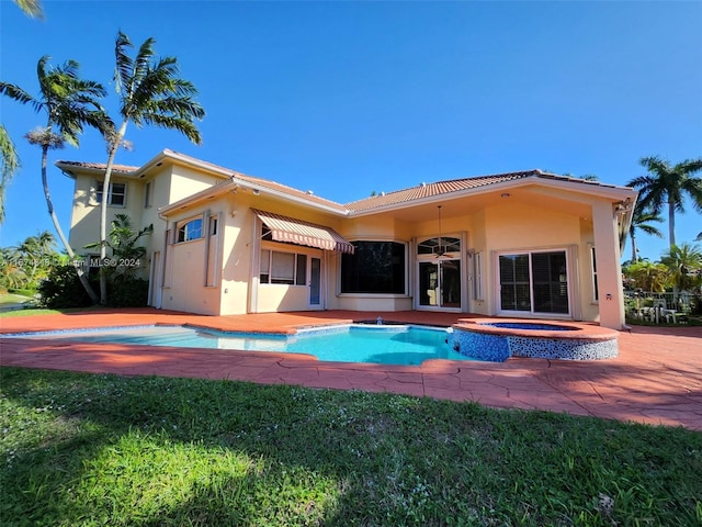 321 Windmill Palm Ave, Plantation, FL 33324 - rear view of property featuring stucco siding, a yard, a pool with connected hot tub, and a tiled roof