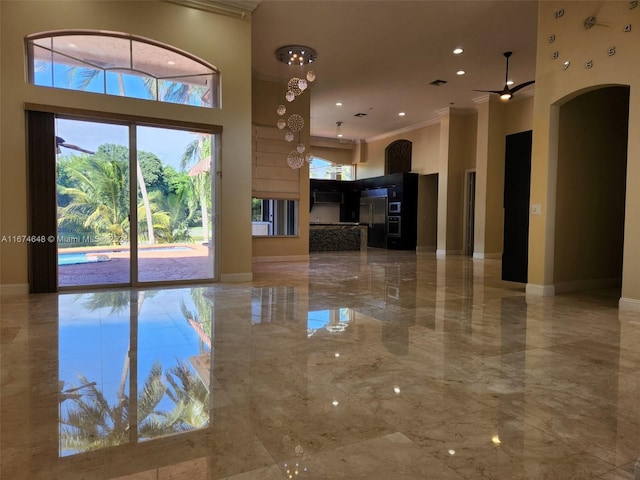 321 Windmill Palm Ave, Plantation, FL 33324 - unfurnished living room featuring light marble finish floors, crown molding, arched walkways, a high ceiling, and ceiling fan