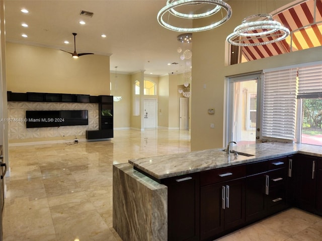 321 Windmill Palm Ave, Plantation, FL 33324 - kitchen with open floor plan, a glass covered fireplace, light stone countertops, ornamental molding, and recessed lighting