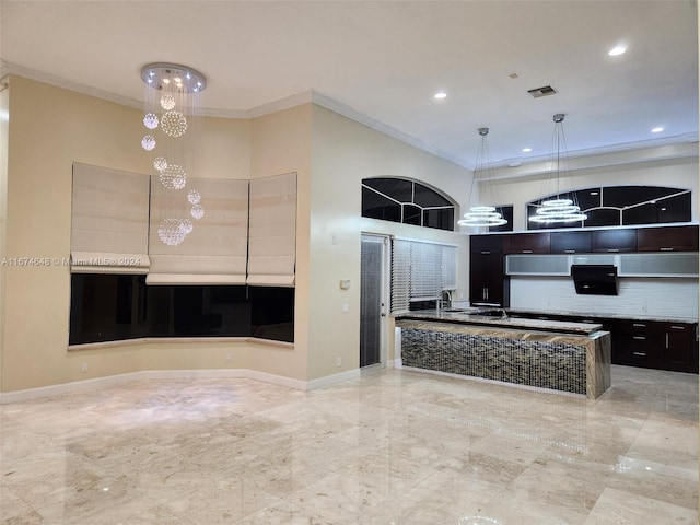 kitchen featuring a towering ceiling, ornamental molding, decorative light fixtures, and sink