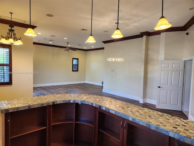 kitchen with crown molding, hanging light fixtures, and dark hardwood / wood-style flooring