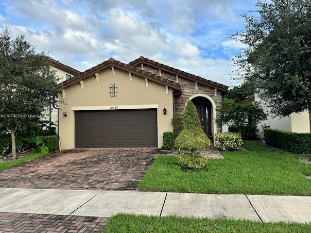 mediterranean / spanish home with a front yard and a garage