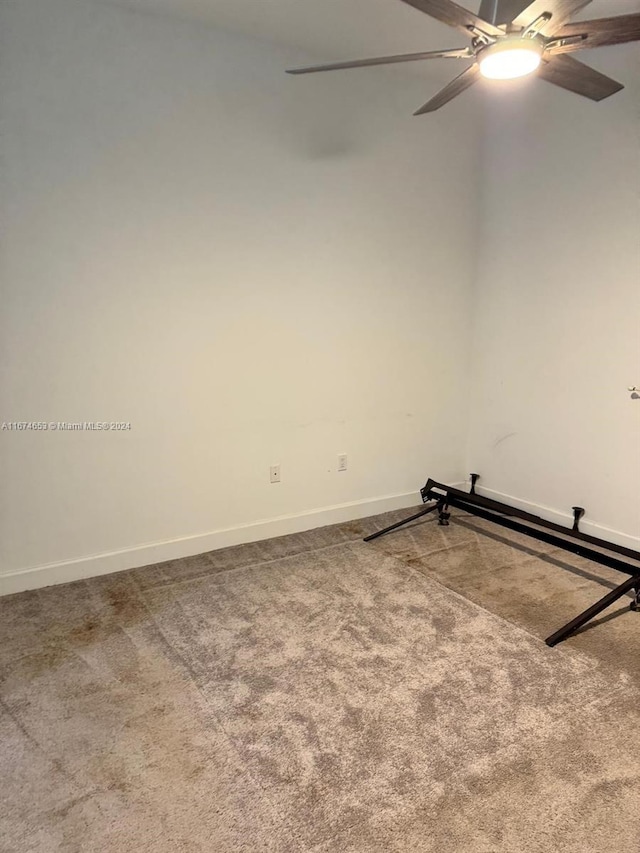 carpeted spare room with ceiling fan