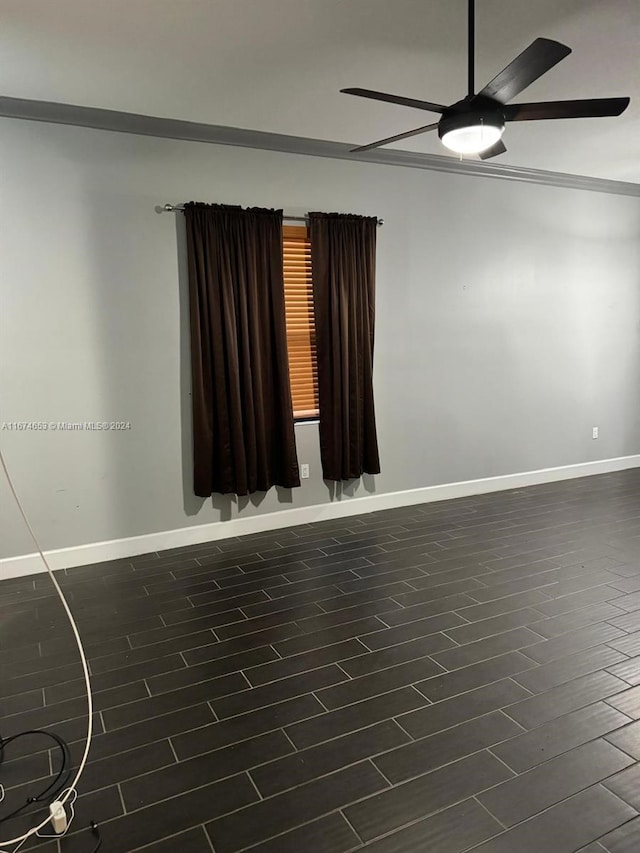 spare room with ceiling fan, ornamental molding, and dark wood-type flooring