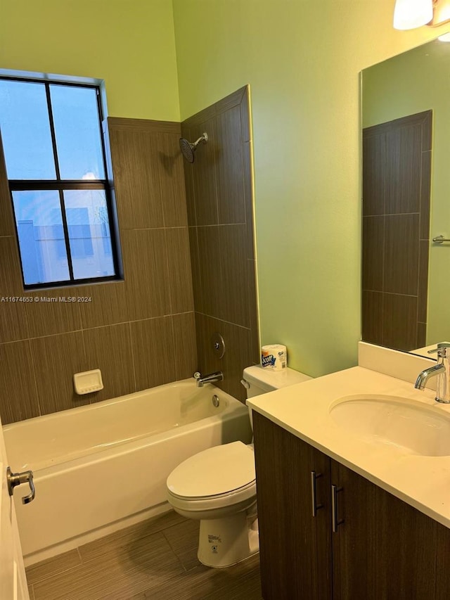 full bathroom with vanity, tiled shower / bath combo, and toilet