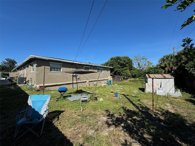 view of yard with a storage shed and central AC