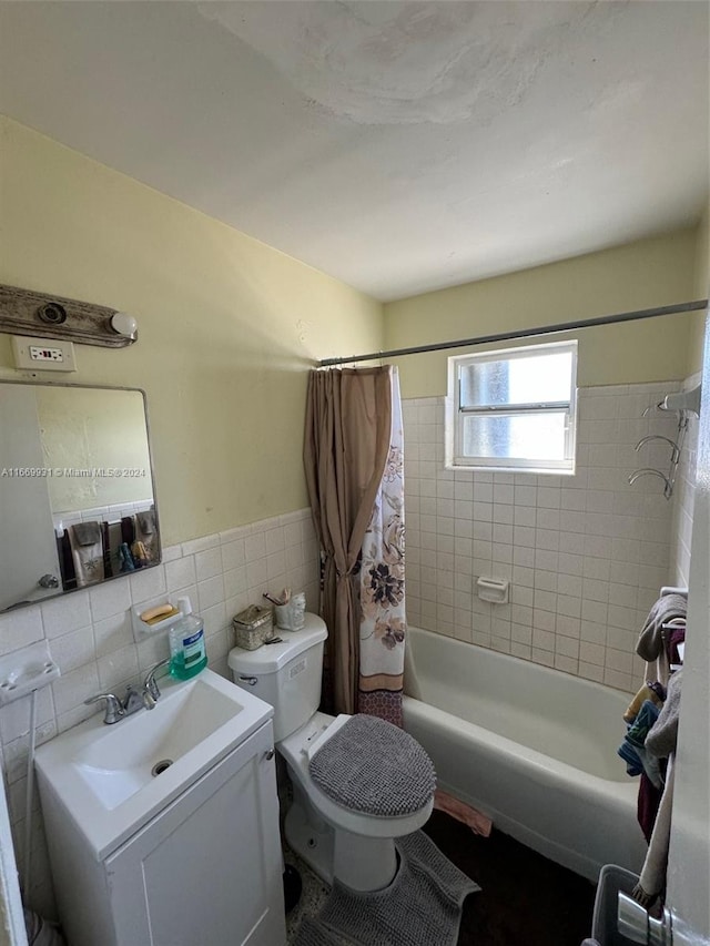 full bathroom with tile walls, shower / tub combo, vanity, and toilet