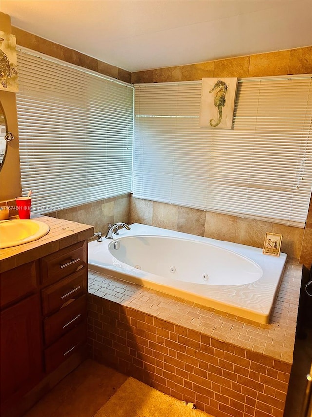 bathroom with tiled tub and vanity