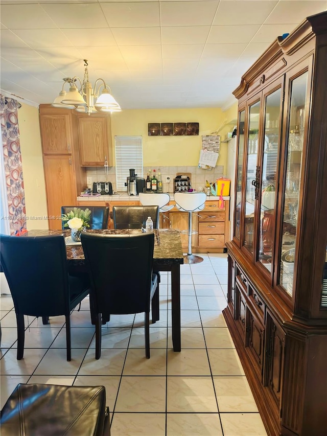 tiled dining space with a chandelier