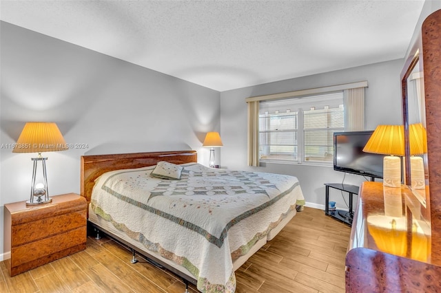 bedroom featuring wood-type flooring and a textured ceiling