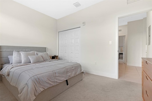 bedroom with light carpet and a closet