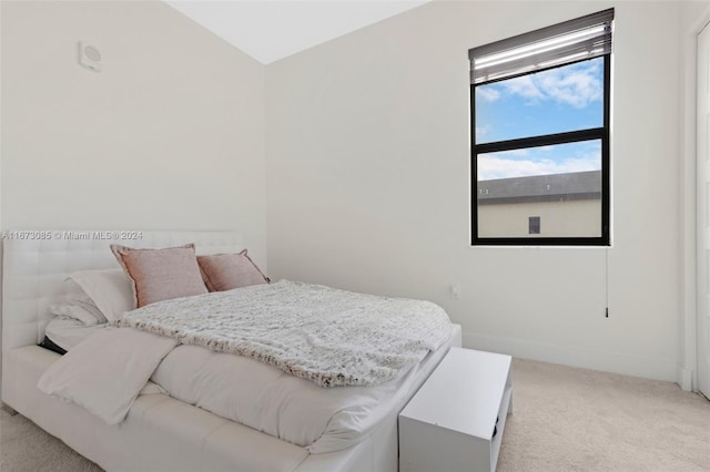 bedroom with light carpet and vaulted ceiling