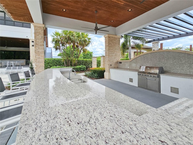 view of patio / terrace featuring a wet bar, ceiling fan, and exterior kitchen