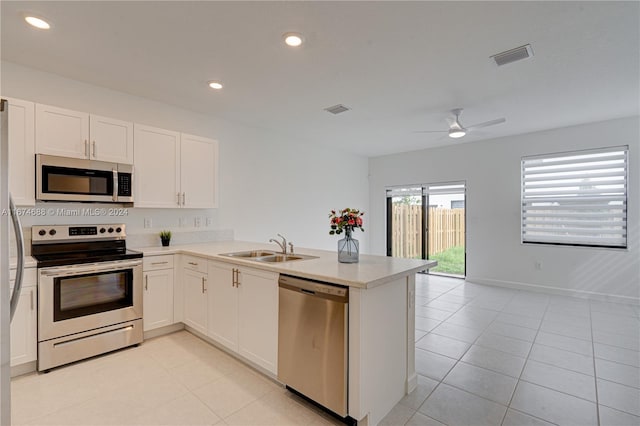 kitchen featuring stainless steel appliances, kitchen peninsula, and white cabinets