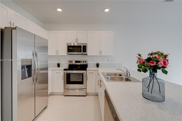 kitchen featuring appliances with stainless steel finishes, sink, and white cabinetry