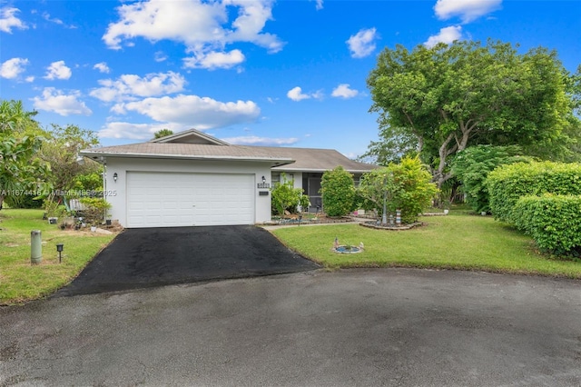 single story home featuring a garage and a front lawn