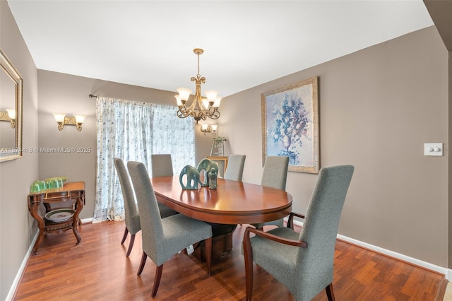 dining area with hardwood / wood-style floors and a notable chandelier