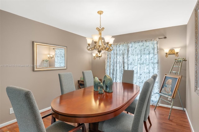 dining room with hardwood / wood-style flooring and a chandelier