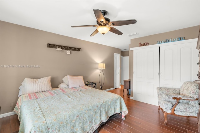 bedroom with dark hardwood / wood-style flooring, ceiling fan, and a closet