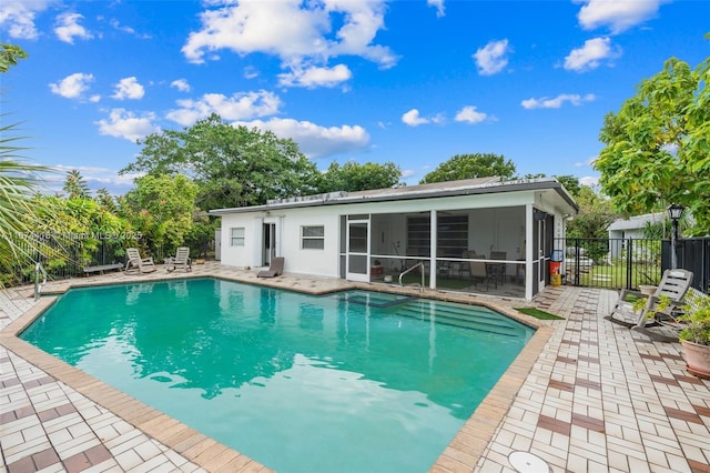 view of pool featuring a patio area and a sunroom