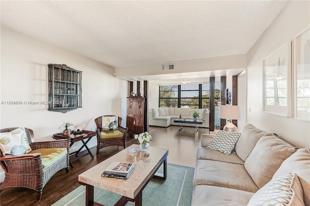 living room featuring hardwood / wood-style flooring, a textured ceiling, and ceiling fan