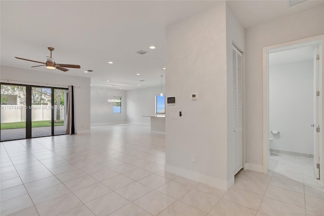 tiled spare room with ceiling fan