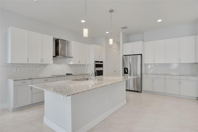 kitchen featuring white cabinets, a kitchen island with sink, sink, wall chimney exhaust hood, and stainless steel appliances