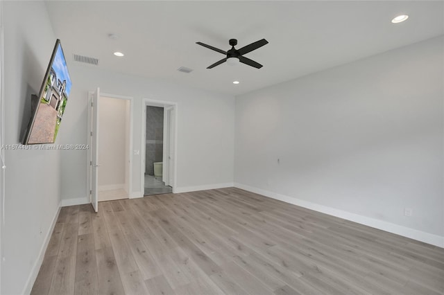 interior space with ensuite bath, light hardwood / wood-style flooring, and ceiling fan