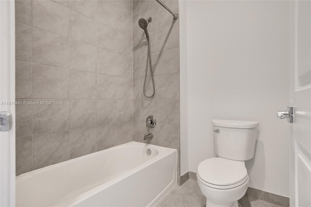 bathroom featuring toilet, tiled shower / bath, and tile patterned flooring