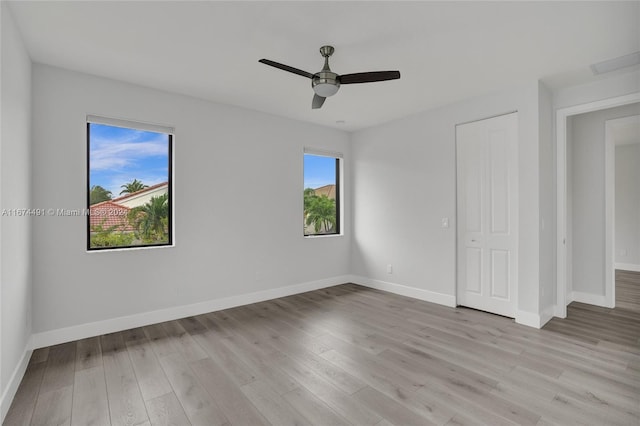 unfurnished bedroom with multiple windows, light wood-type flooring, and ceiling fan