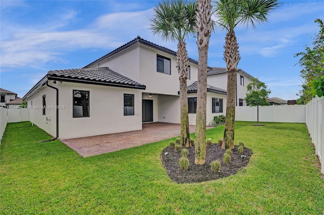 rear view of property with a yard and a patio