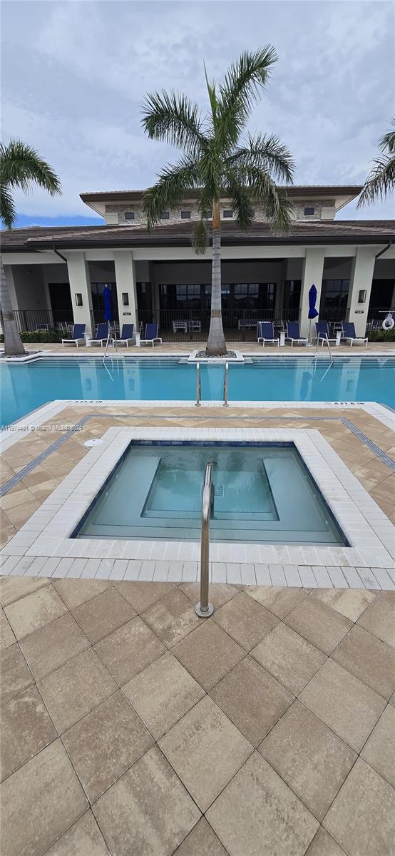 view of swimming pool with a patio area and a community hot tub