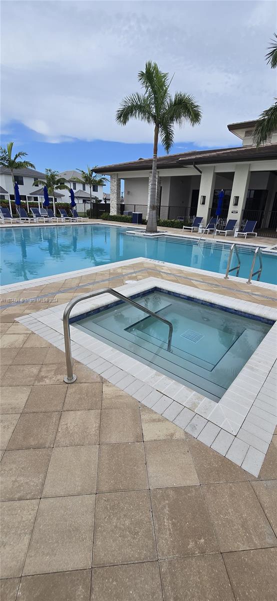 view of swimming pool with a hot tub