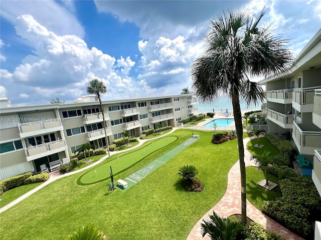 surrounding community featuring a lawn and a swimming pool