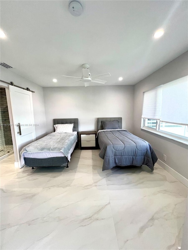 bedroom featuring a barn door and ceiling fan