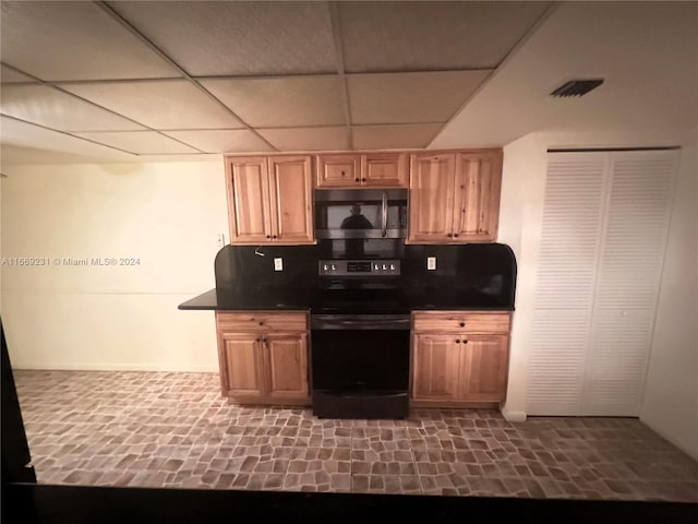 kitchen featuring a drop ceiling, backsplash, and black range with electric stovetop